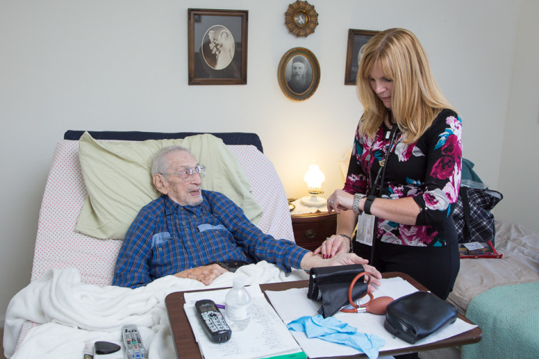 Nurse Jeanette Hutchinson checks veteran Bob Swisky's vital signs.