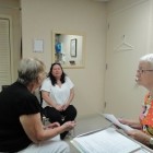 Juana Pecunia, (at left) speaks through her interpreter, Glenda Wagner, as her doctor listens.
